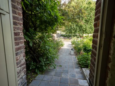 Sortie de la cour intérieure de l'Anc. Seigneurie de Boucaut avec les gîtes sur la gauche et les espaces verts sur la droite